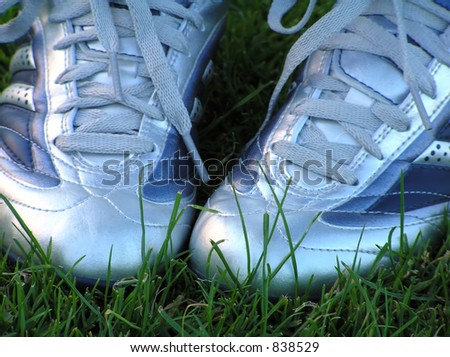 Pair of soccer shoes on green grass