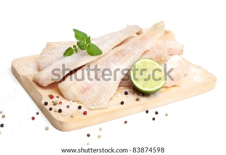 frozen pollock (pallock) and spices on wooden board isolated