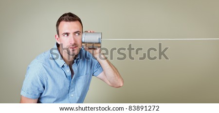 Man listening to tin can telephone Royalty-Free Stock Photo #83891272
