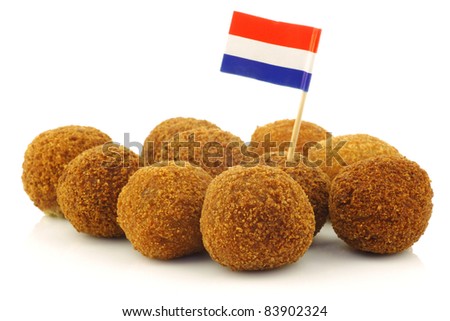 A real traditional Dutch snack called "bitterballen" with a Dutch flag toothpick on a white background Royalty-Free Stock Photo #83902324