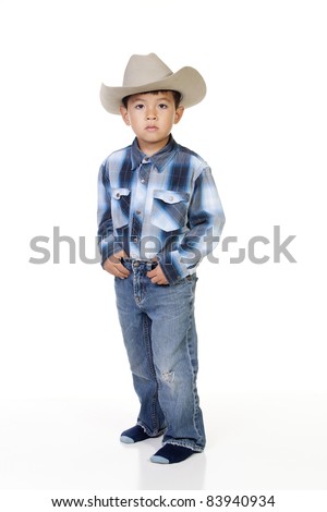 A young boy plays dress up in cowboy outfit.