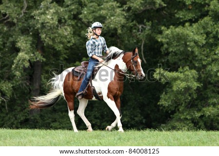 Teenage girl riding a running horse Royalty-Free Stock Photo #84008125