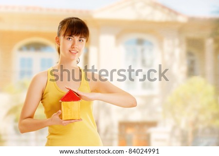 Young woman with toy house isolated on white background
