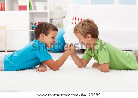 Boys arm wrestling in the kids room - childhood rivalry