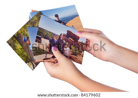 Female hands holding several family vacation photographs