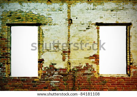 an old brick wall with two windows with a blank space