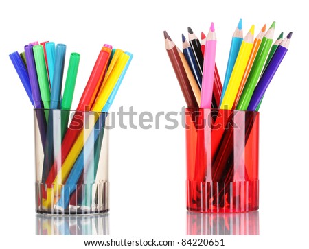 Bright markers and crayons in holders isolated on white