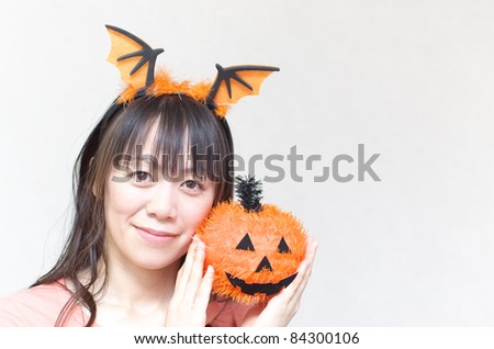 Asian woman holding a Halloween pumpkin