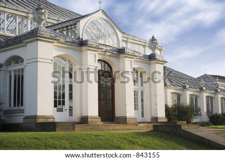 entrance of a white mansion with the sky at the background