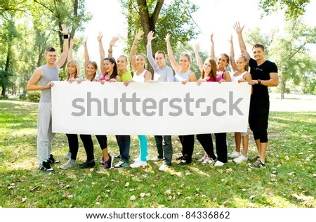 large group of young people holding a big white board