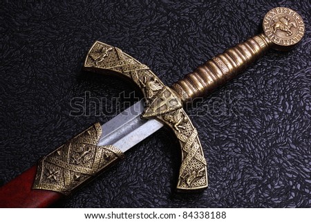 Ancient sword with the bronze handholdon a beautiful background Royalty-Free Stock Photo #84338188