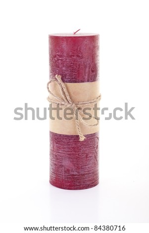 A red Christmas candle on white tied with a string bow