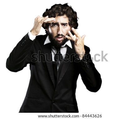 portrait of young business man looking in the mirror against white background