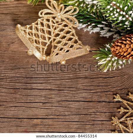 Christmas border from branch and bells on wooden background