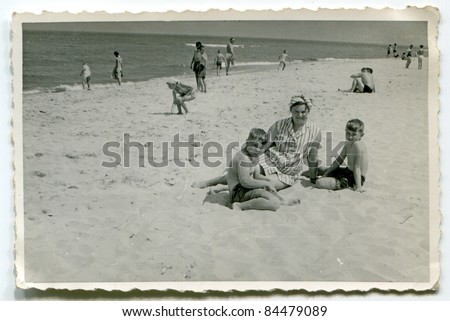 Vintage photo of mother with sons on beach (fifties)