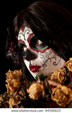 Portrait of Sugar skull girl with dead roses, isolated on black background