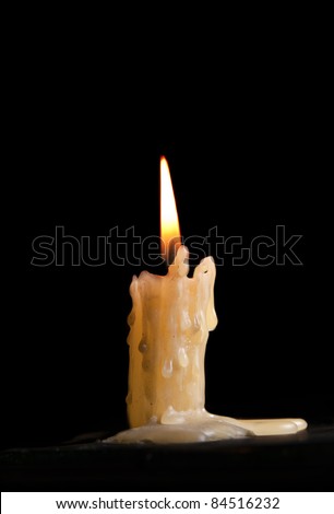 Burning candle against a black background