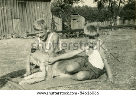 Vintage photo of boys playing with a dog (fifties)