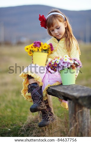 Cute adorable little girl holding bunch of flowers