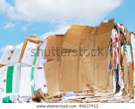Closeup on carton packages recycling: against blue sky
