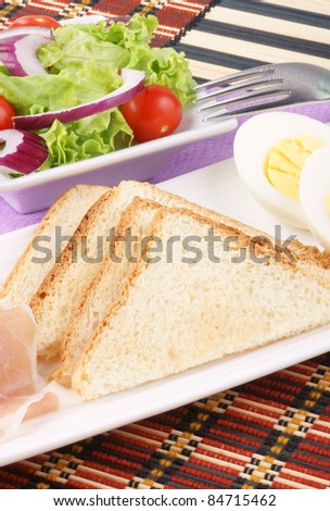 Snack food: toasted slices of bread, jam, boiled egg and mixed salad