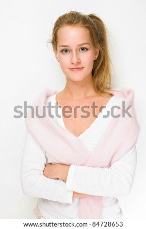 High key portrait of confident fashionable young blond girl with pink sweater and white shirt