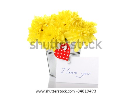 Yellow chrysanthemums in a bucket with chrysanthemums next card with the text "I love you" and a pin with a red heart. Isolated