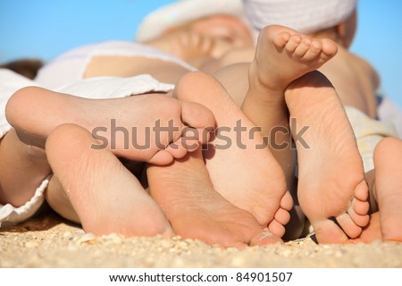 Photo of  family lying on sand on background of blue sky