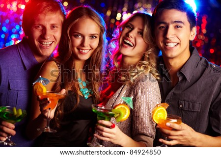 Image of two happy couples holding glasses of cocktails
