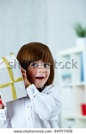 Photo of surprised boy with giftbox