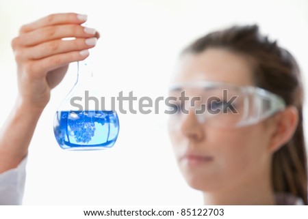 Close up of a scientist looking at flask with the camera focus on the object