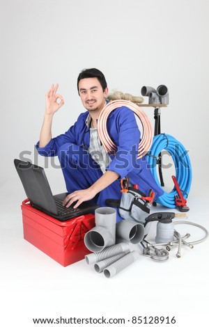plumber kneeling with computer doing OK sign