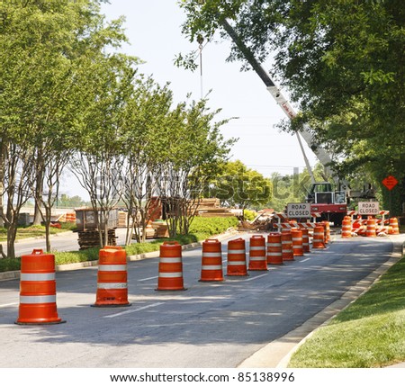 A road construction project with orange and white barrels