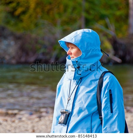 AdventureIsAgeless. Portrait of woman tourist against a background of the mountain river