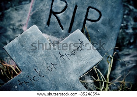trick or treat written in a cross on a cemetery