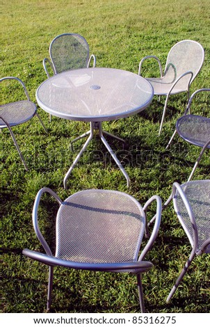 metal chairs and table on the park grass