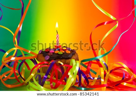 Birthday cupcake with colorful decoration and candle