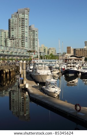The marina and waterfront towers reflected in the calm water of Coal Harbor. Vancouver, British Columbia.