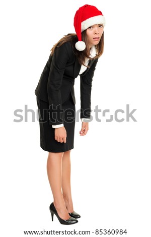 Christmas business woman tired wearing santa hat standing bored bending over. Christmas business concept of businesswoman stressed and exhausted isolated in full body on white background.