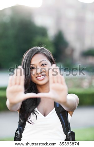 A shot of an Asian student making a frame with her hands