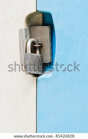 The blue door is locked with a old padlock.