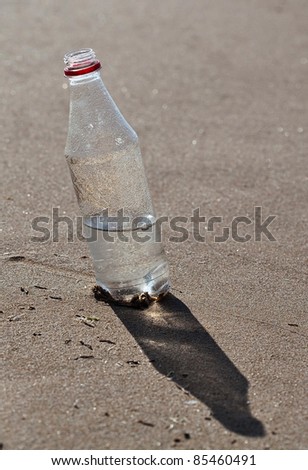 water bottle on the sand, extreme closeup