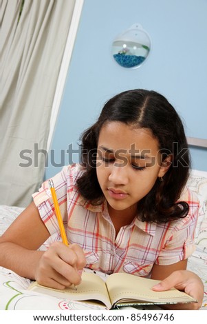 Girl writing in her journal from bed