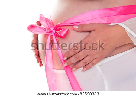 A bow on a belly of a pregnant woman isolated on white