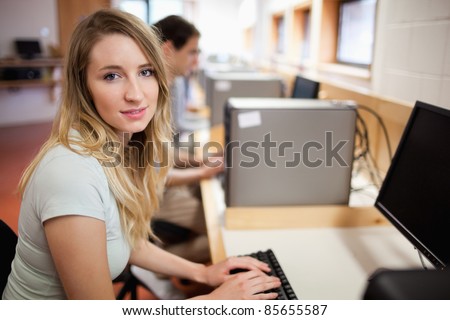 Student posing with a computer in an IT room
