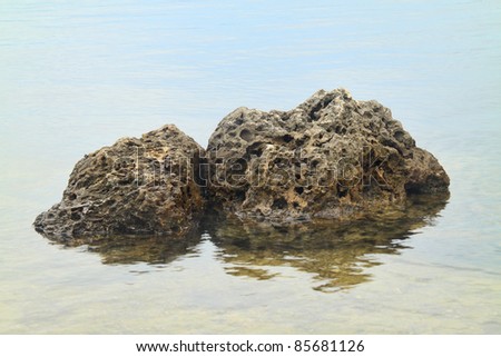 Rocks sitting in the water “like a rock” to portray strength and stability