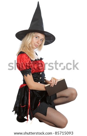 teenager girl in Halloween witch reads magic book
