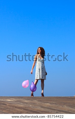 young girl walks and waves the balloons