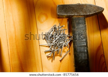 Hammer and nails isolated on the wooden background