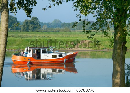 Little orange motor boat for recreation purpose in river